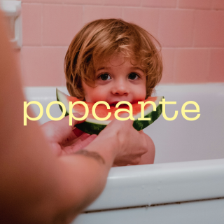 Enfant dans un bain mangeant une tranche de pastèque, texte popcarte en surimpression