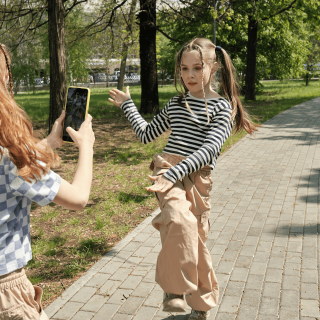 Une fille filmant une autre fille qui danse dans un parc