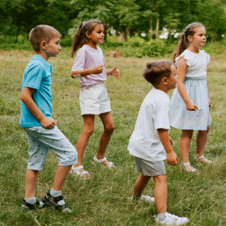 Quatres enfants qui jouent dans l'herbe