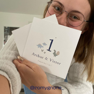 Une femme qui tient une carte anniversaire 1 an Arthur & Victor 