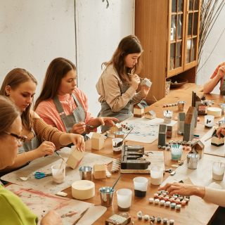 Filles assissent autour d'une table et font de la peinture sur céramique
