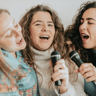 Trois filles qui chantent avec des micros